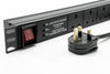 Partial close-up slanting left front view of a 1U 19" 6 Way Horizontal Switched 13A UK Sockets to UK input Plug Rack PDU with Surge Protection.